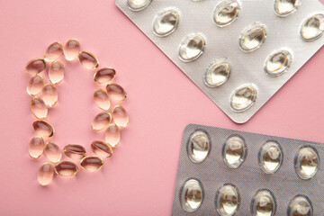 Vitamin D capsules in the shape of letter D on pink background