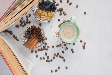 An opened book with cup and coffee beans on marble background