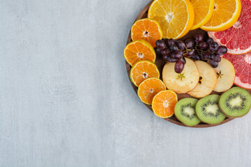 Various fruit slices on wooden plate