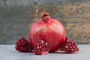 Pomegranate and pomegranate seeds on stone table