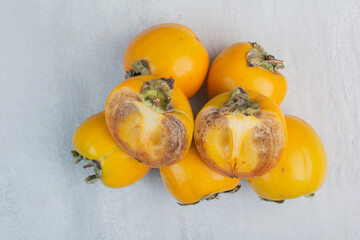 Bunch of tasty persimmons on stone background