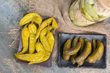 Pickled cucumbers with salty peppers on sackcloth
