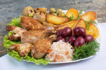 Delicious chicken fried legs with salty vegetables and fried potatoes