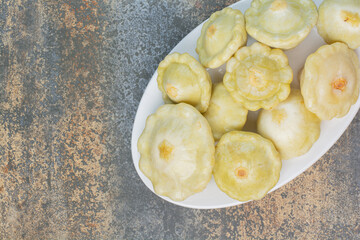 A white plate of delicious fruits on marble background