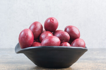 A dark plate of delicious fruits on white background