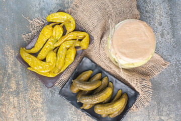 Pickled cucumbers with salty peppers on sackcloth