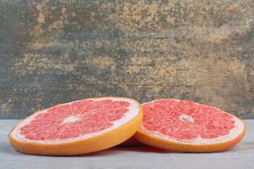 Juicy grapefruit slices on stone background