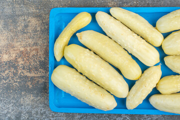 Salty delicious cucumbers on blue plate