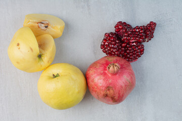 Pomegranate and quinces on stone background