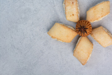 Tasty stuffed biscuits and cake on gray background