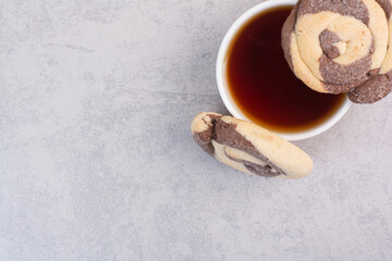 Round cookies and cup of tea on gray background