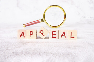 word appeal written on wooden cubes with a magnifying glass in the background - obrazy, fototapety, plakaty