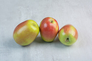 Three fresh apples on stone background