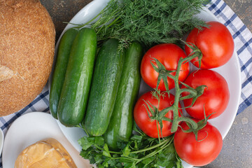 Vegetable plate and bread on marble background