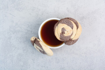 Round cookies and cup of tea on gray background