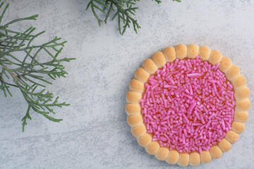 Tasty cookie with sprinklers on gray background