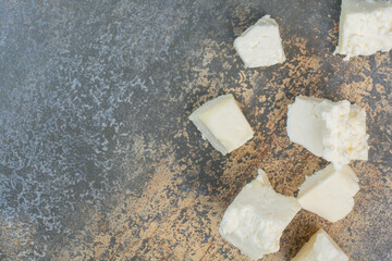 Slices of white cheese on marble background