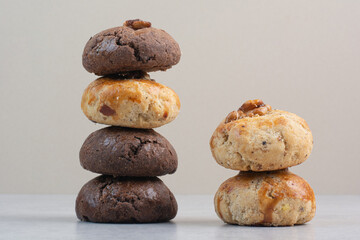 Fototapeta na wymiar Stack of various cookies with walnut on beige background