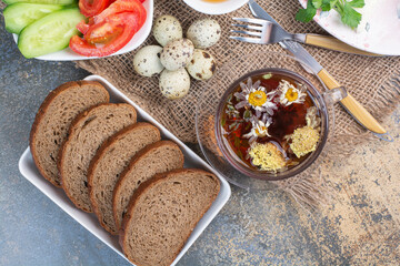 Breakfast table with vegetables, tea, bread and eggs on burlap