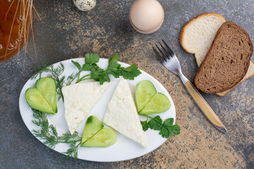 Cheese plate with vegetables and bread slices
