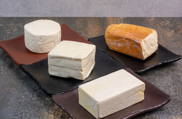 Different kinds of cheese on dark plates