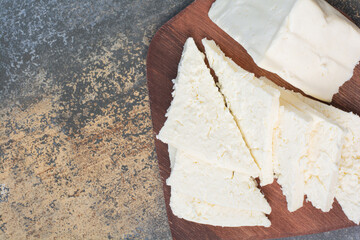 Various white cheese on wooden board