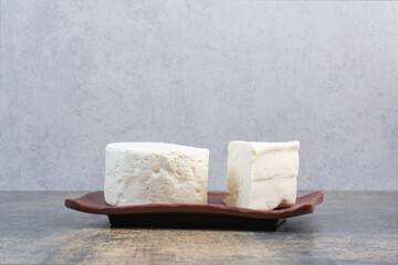 White whole cheese and slice on brown plate