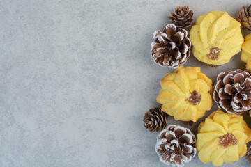 A lot of fresh delicious cookies with small pinecones on white background