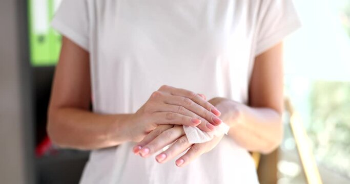Right hand wipes left hand with piece of damp cloth