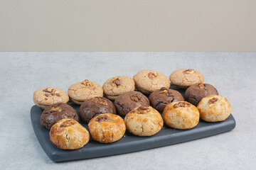 Round fresh delicious cookies on dark plate