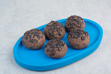 Round chocolate delicious cookies on blue plate
