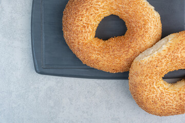 Two fresh delicious bagels on dark plate