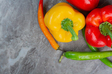 Tasty whole peppers on marble background