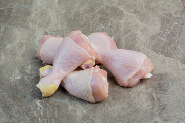 Fresh uncooked chicken legs on marble background