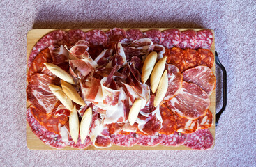 appetizing board of assorted iberian cold cuts with breadsticks and acorn-fed iberian ham