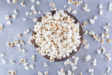 Fototapeta na wymiar Popcorn in a bowl and scattered all over on marble background