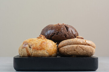 Round fresh delicious cookies on dark plate