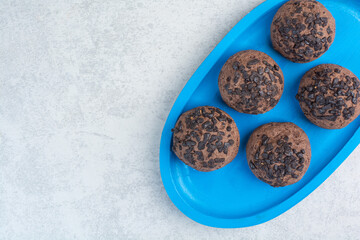 Round chocolate delicious cookies on blue plate