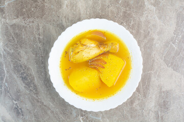Tasty soup with chicken meat and potato on white plate