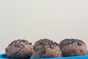 Round chocolate delicious cookies on blue plate