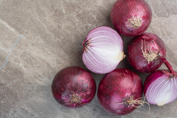 A lot of red onion bulbs on marble background