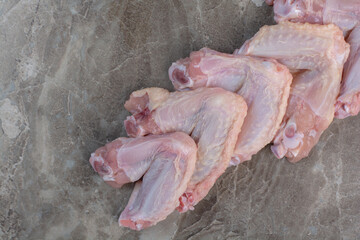 Raw chicken legs on marble background