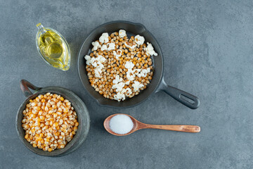 Popcorn making ingredients prepared and ready to cook on marble background
