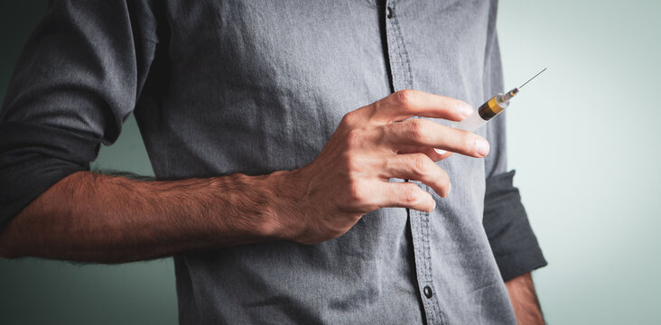 Young Man Holding A Syringe In Her Hand