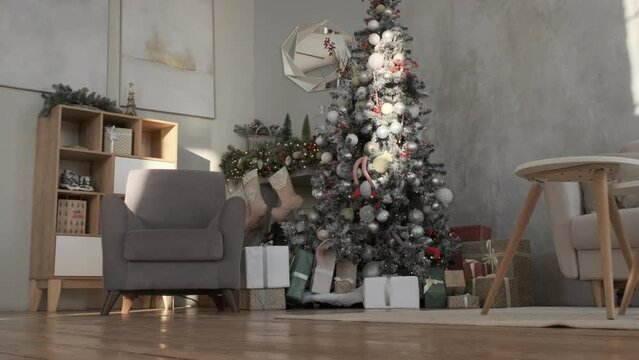 Festive decorated Christmas interior of living room with gifts, garland lighting and stockings on a fireplace