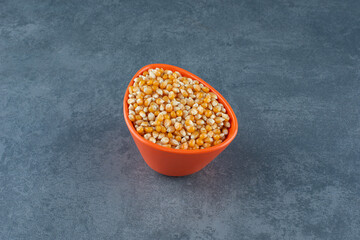 Bowl of corn grains on marble background