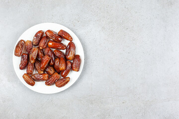 A fresh and succulent plate of dates on marble background