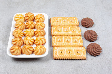 Cookies and biscuits lined up in a plate and on marble background