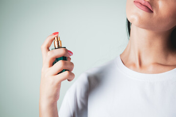 woman sprinkles perfume on her neck
