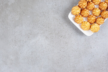 Savory cookies arranged on a white plate on marble background